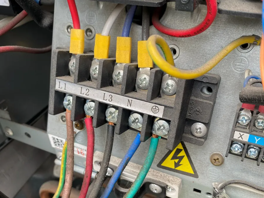 Conexión eléctrica trifásica en la bornera de un equipo, en Canning