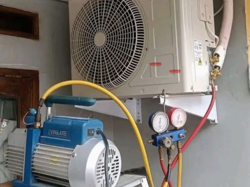 Reparación de un aire acondicionado split en Temperley: unidad exterior conectada a bomba de vacío y manómetros